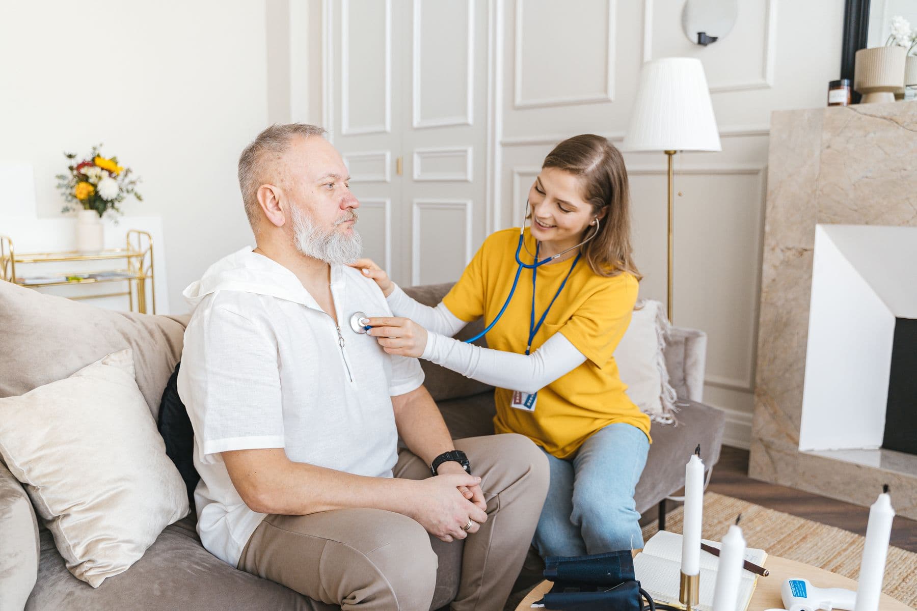 A home care professional checking on an adult client in his living room